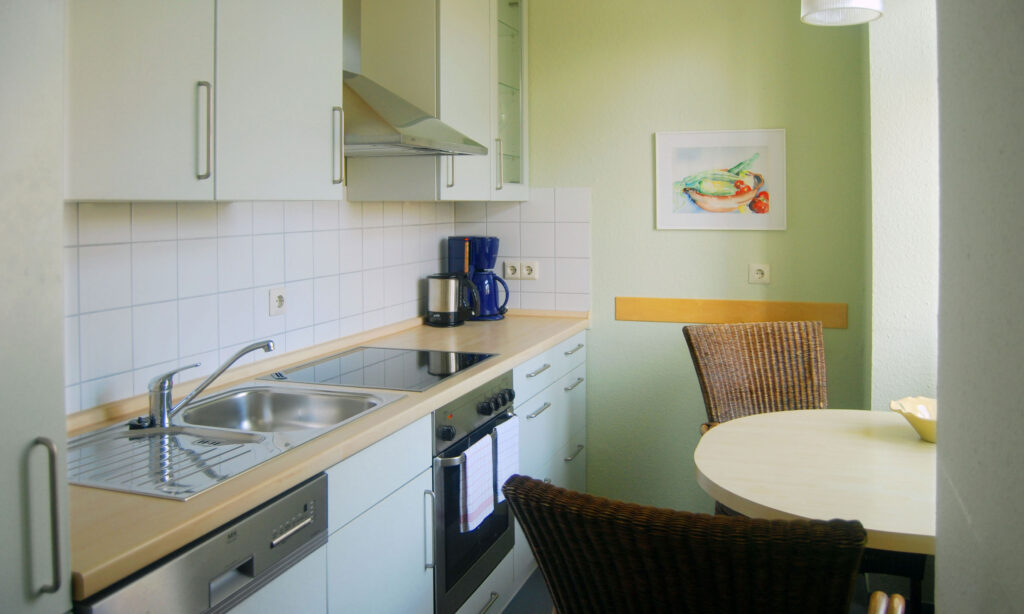 Blick in den Küchen- und Essbereich in der Ferienwohnung 222, das Fenster geht Richtung Landungsplatz