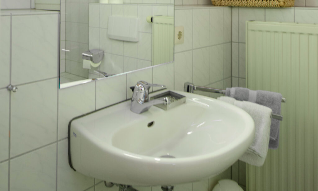 Detail des zeitlos gestalteten Bades/WC in der Ferienwohnung 444